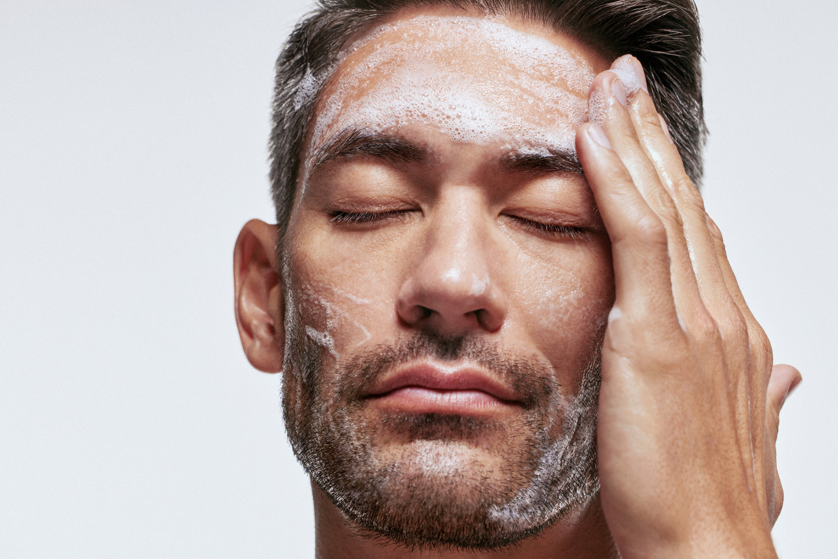 An image of a man washing his face