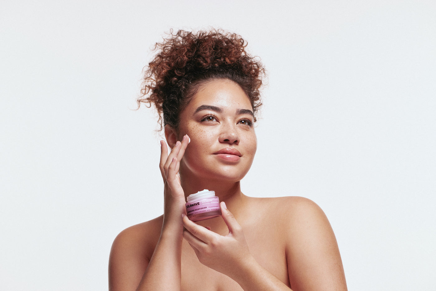 An image of a woman using face cream in her winter skincare routine