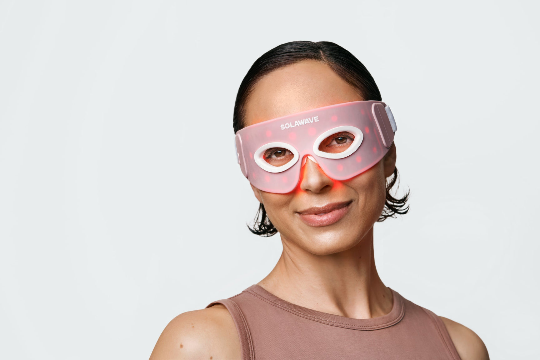 An iamge of a woman wearing red light therapy eye mask to target the wrinkles around the eye area