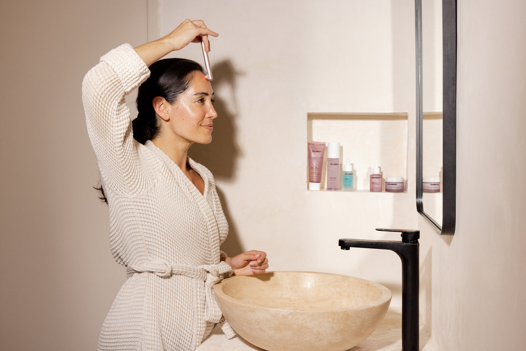 An image of a woman applying serum to her face