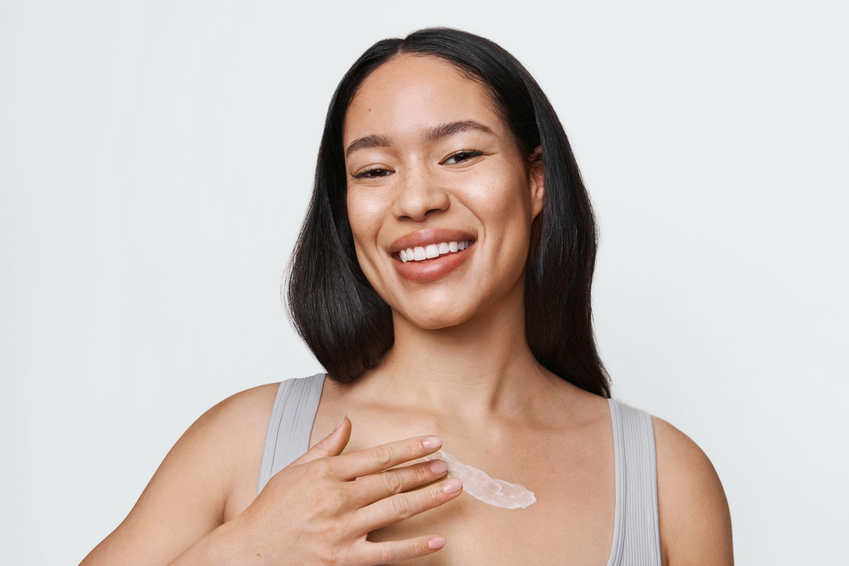 An image of a woman applying skincare to her chest