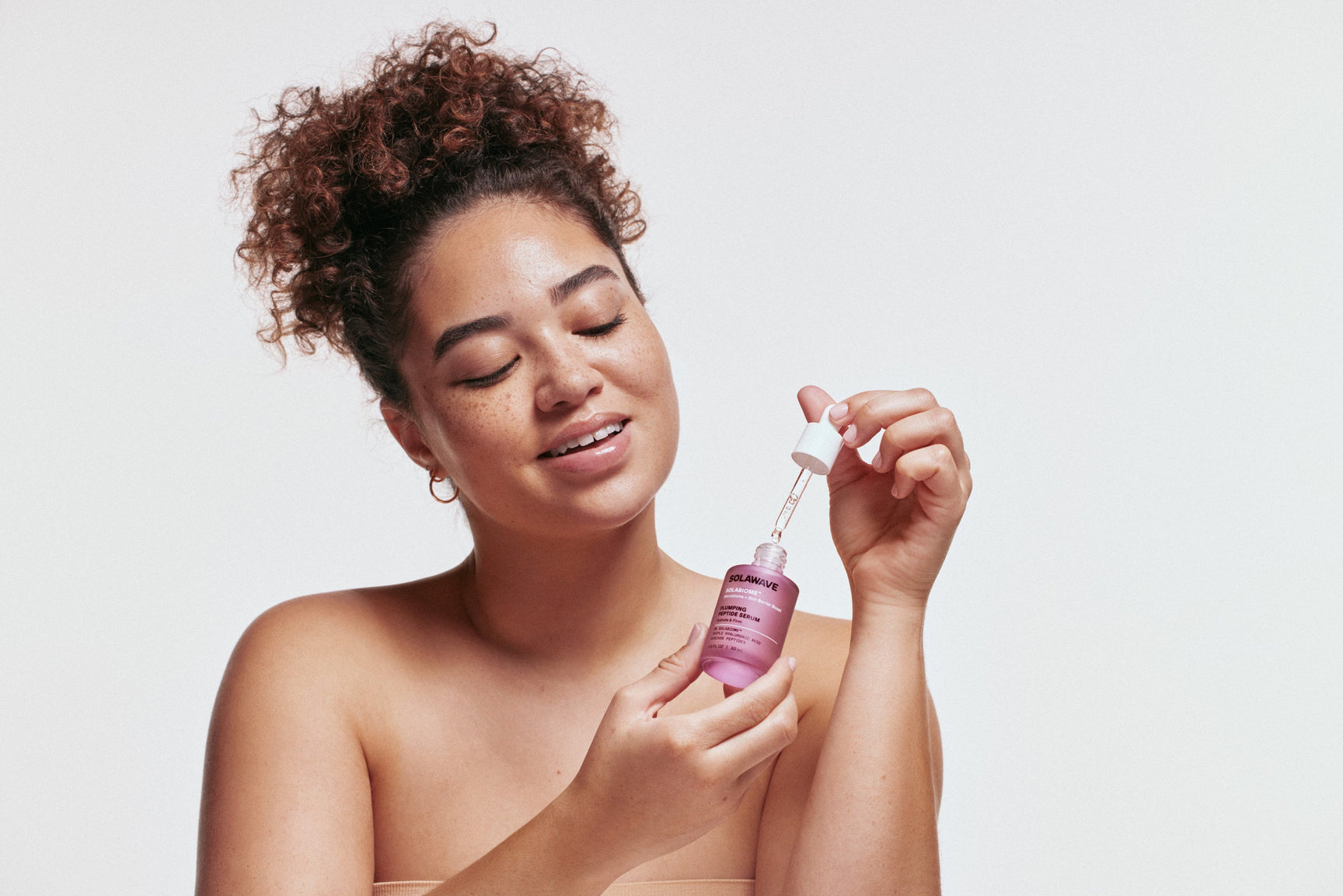 An image of a woman using Hyaluronic Acid serum