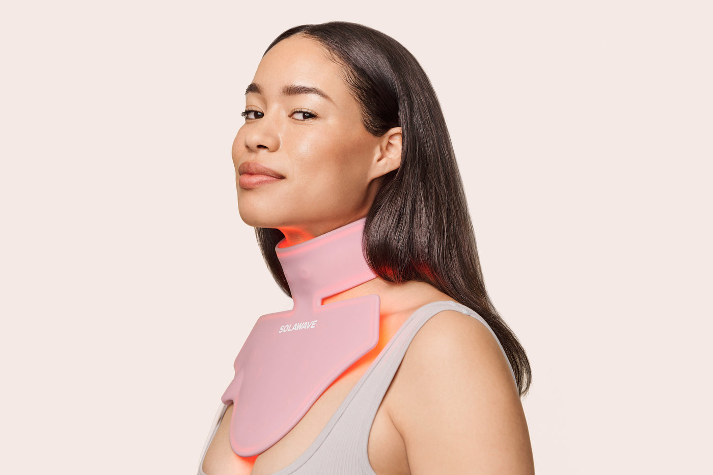An image of a woman wearing a neck and chest red light mask