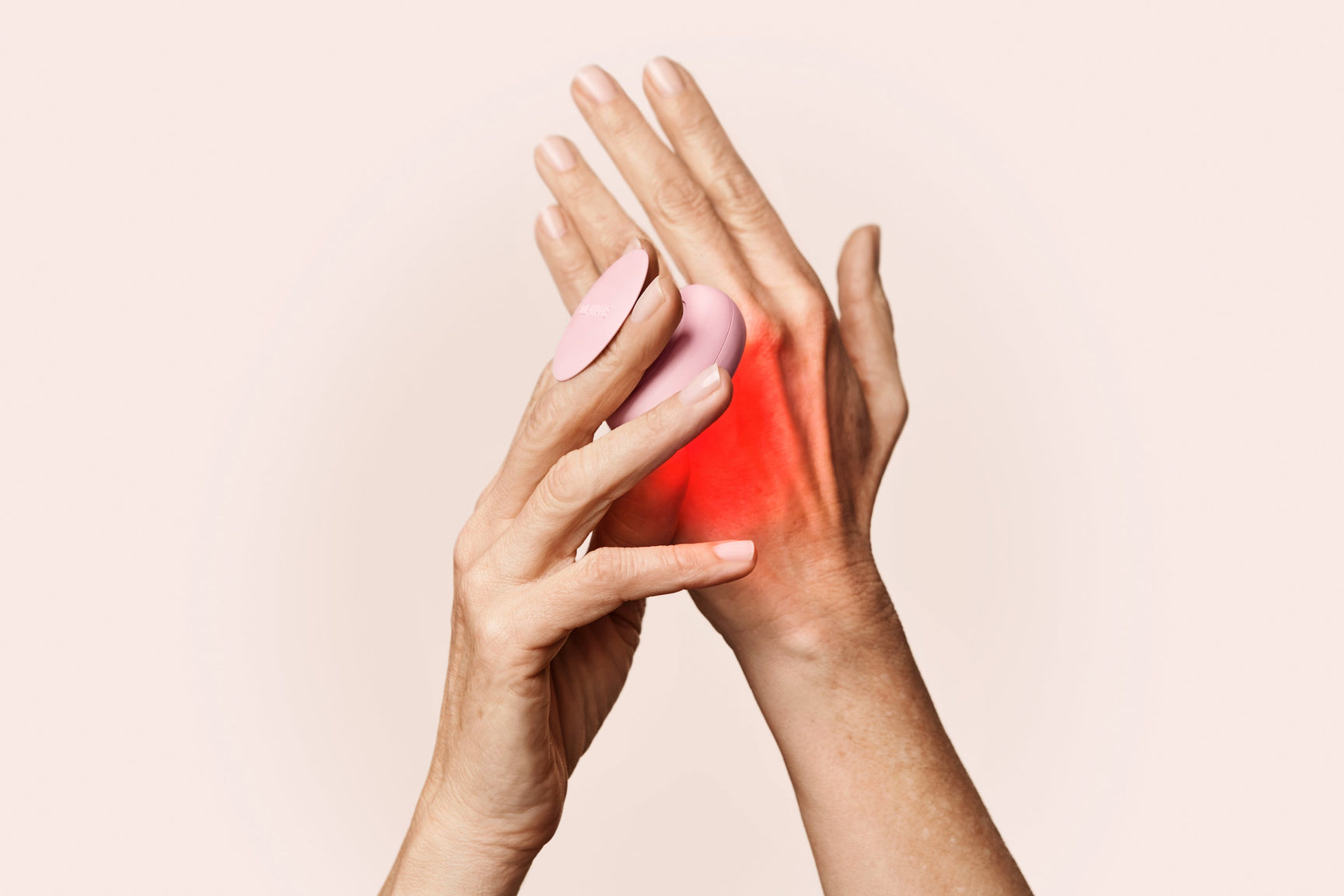 An image of red light therapy done on the hand