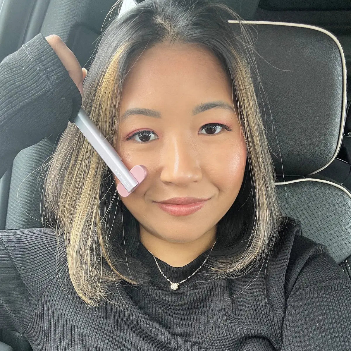 An image of a woman doing at-home red light therapy on her face