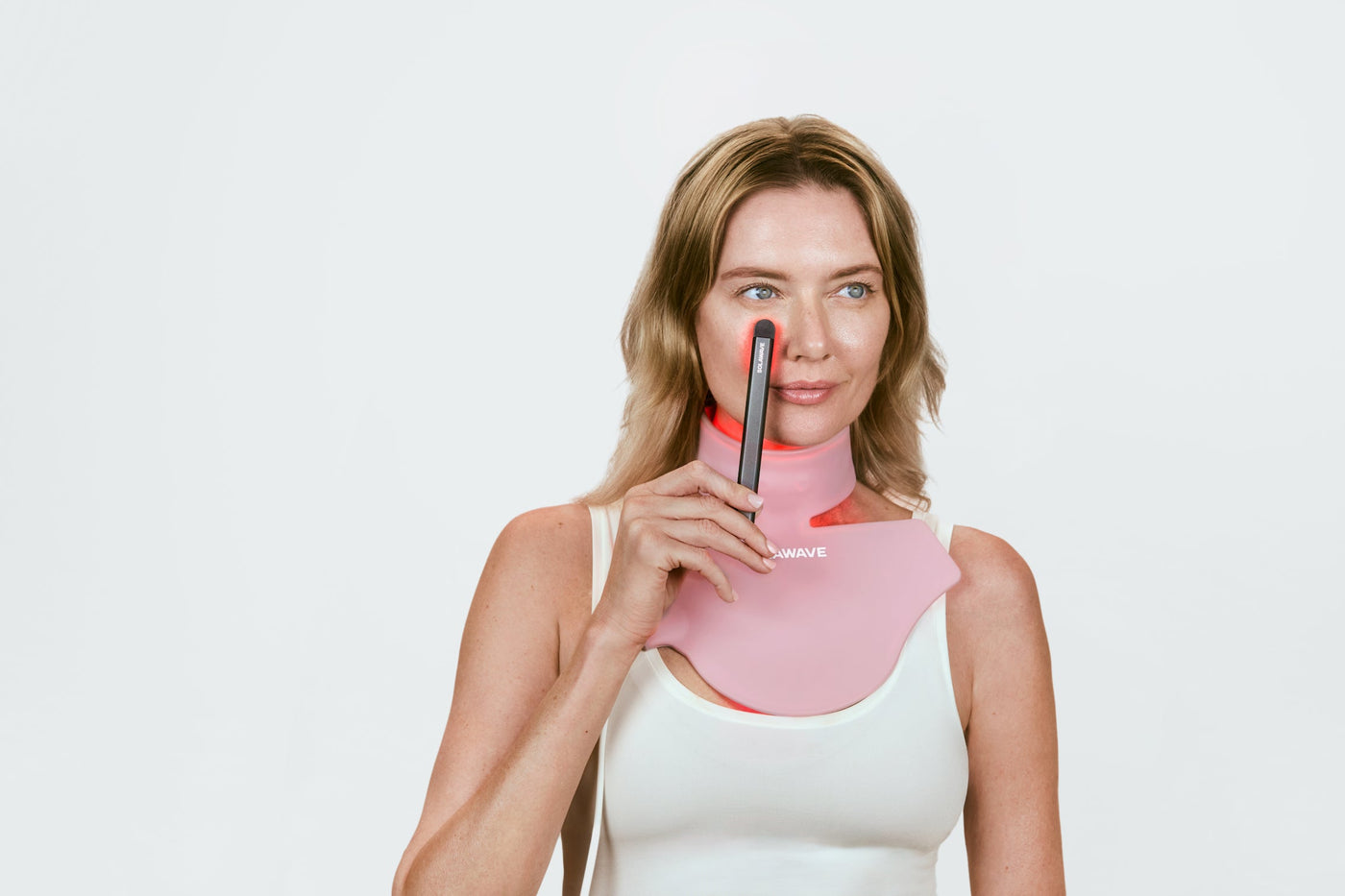 An image of a woman using red light therapy on her face and neck