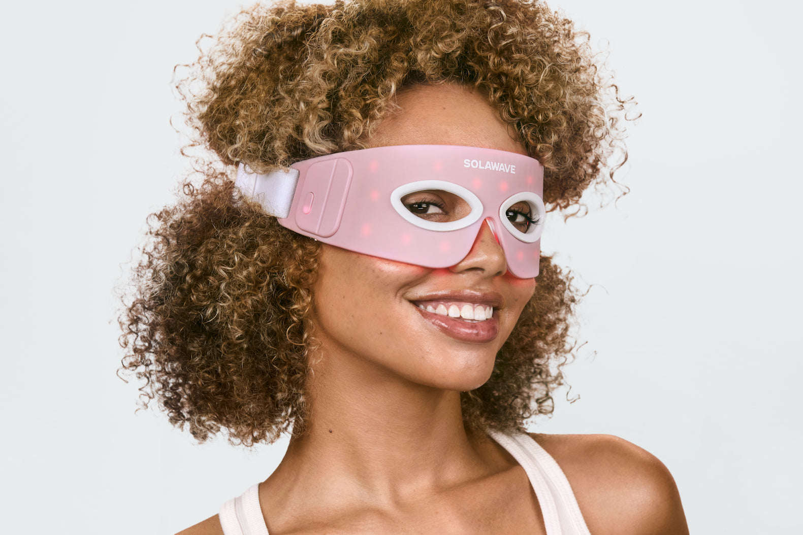 An image of a woman wearing a red light therapy eye mask to target dark circles