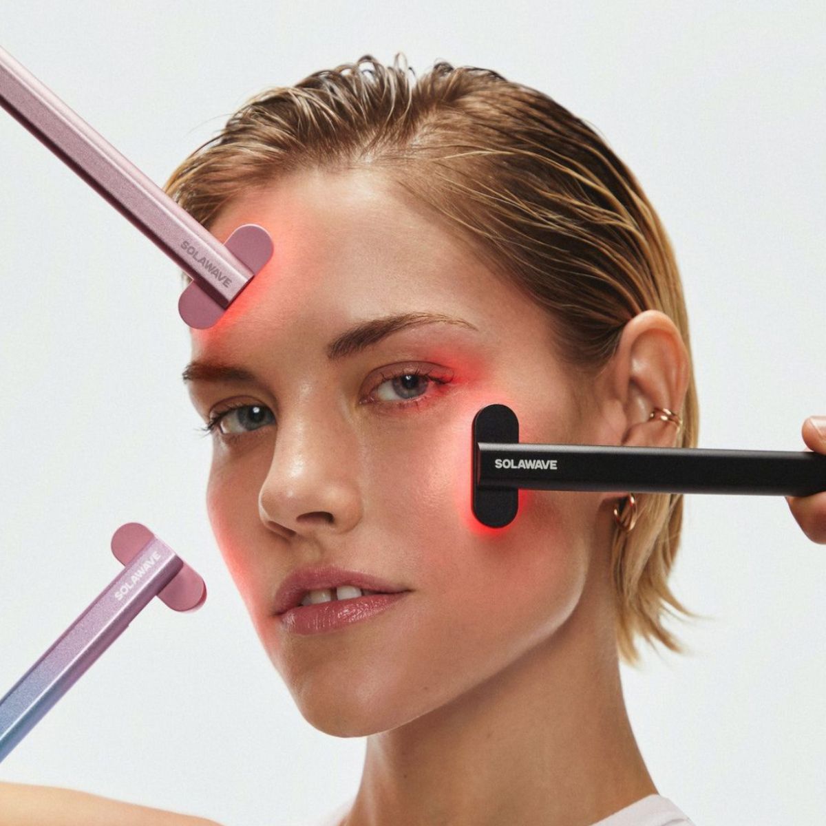 An image of a woman using the Solawave device, the best at home red light therapy device