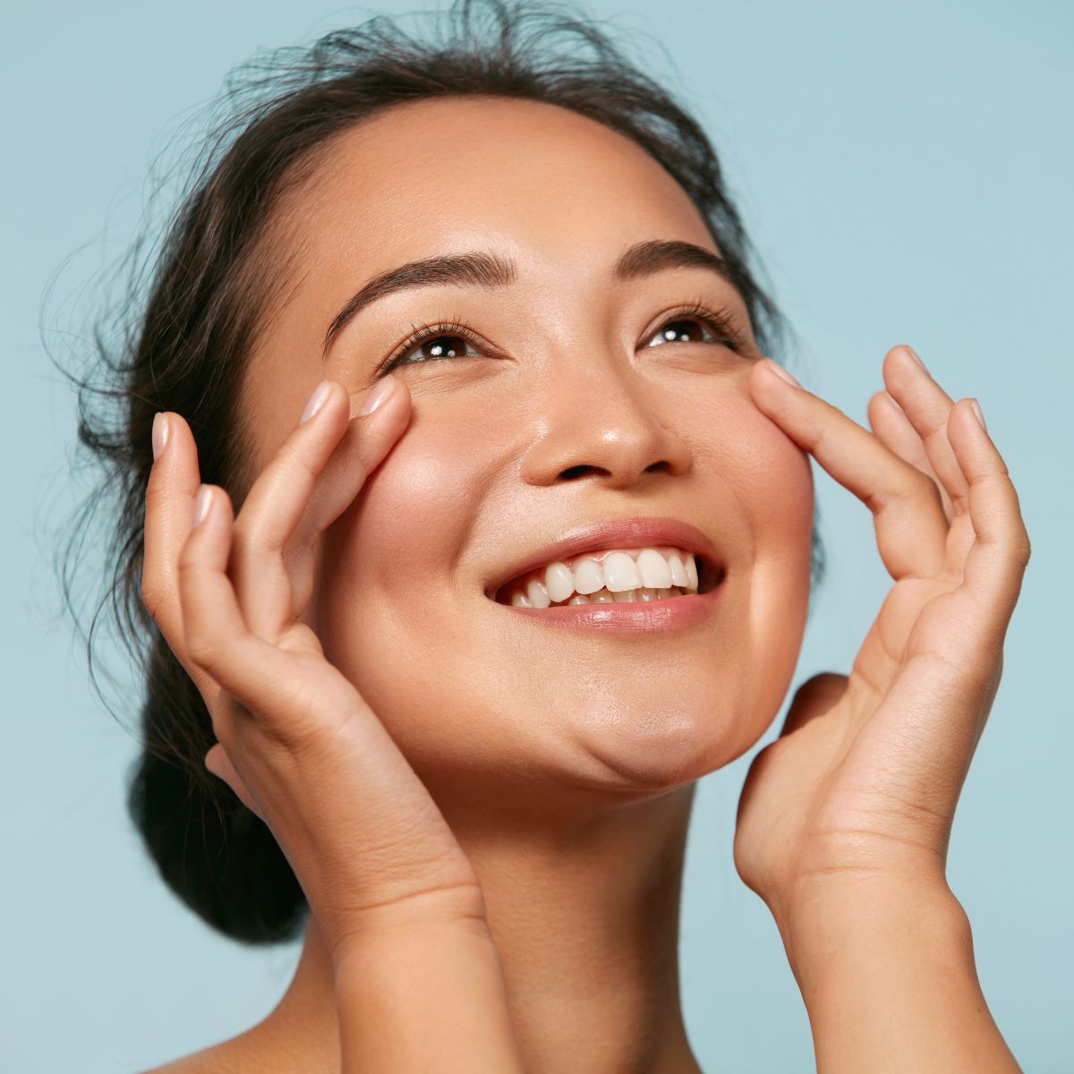 An image of a woman touching her face after getting red light therapy