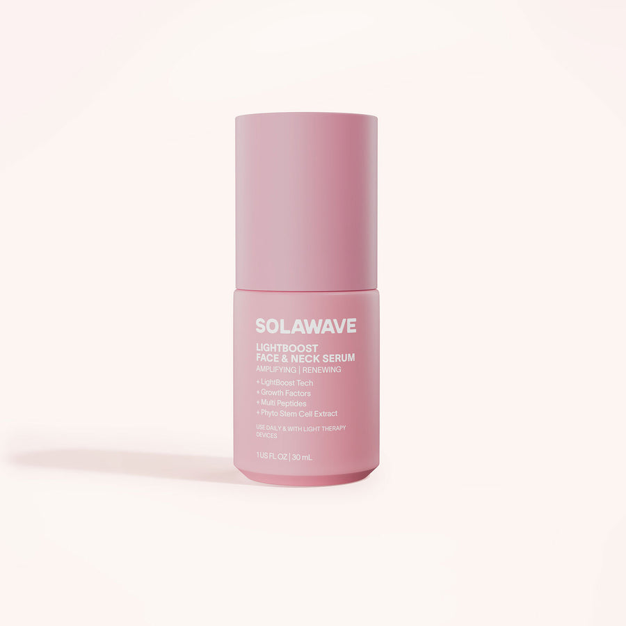 A pink bottle of Solawaves LightBoost Face & Neck Serum sits against a pale background, highlighting its benefits: lightweight, rich, smooths fine lines with a LightBoost Complex and plant-based components. Capacity is 1 fl. oz. (30 ml).