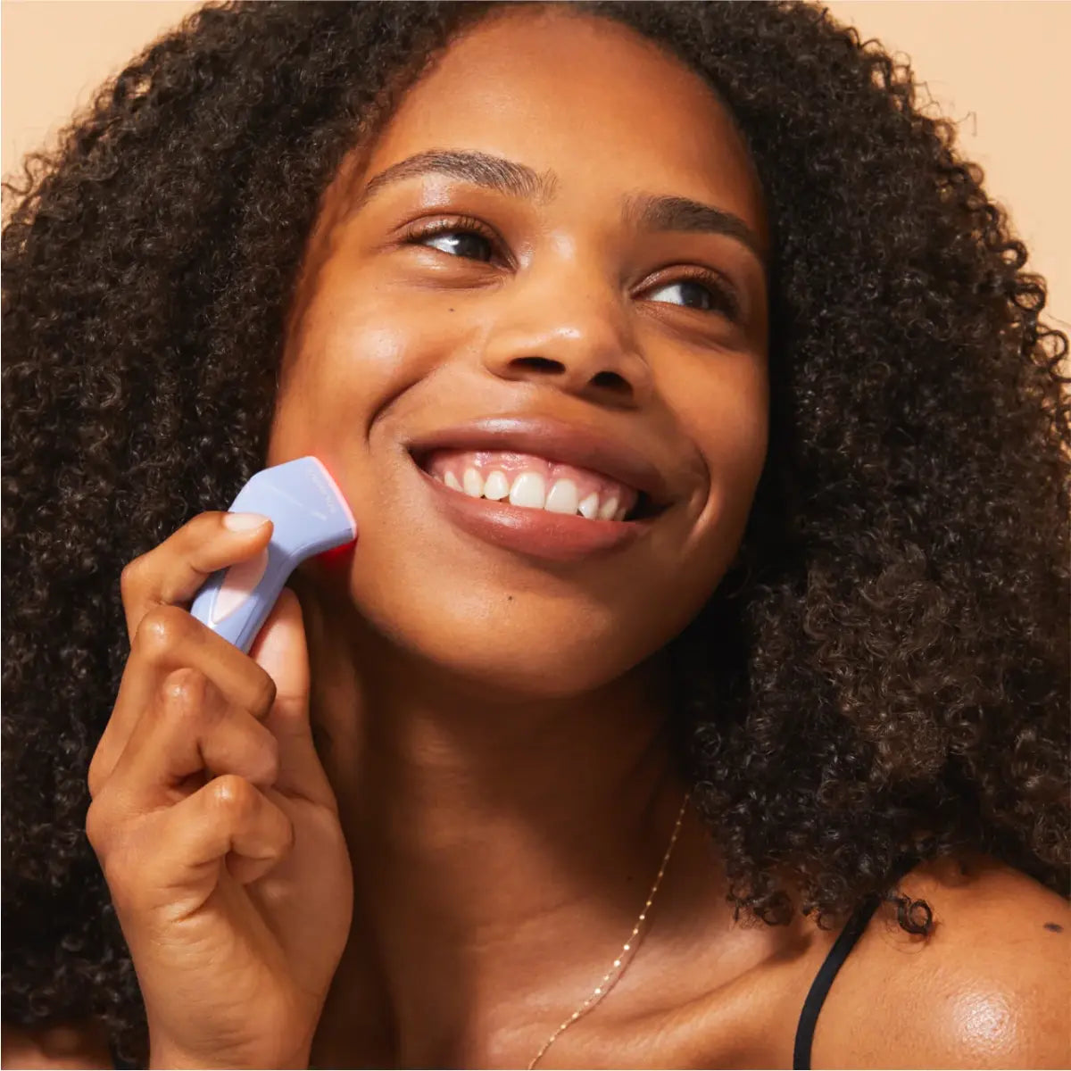 A woman treating acne with blue light therapy