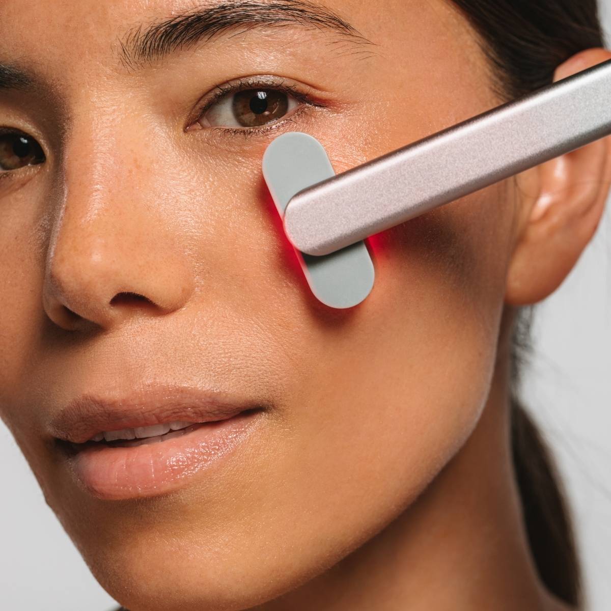 An image of a person using the Solawave red light therapy device on their face