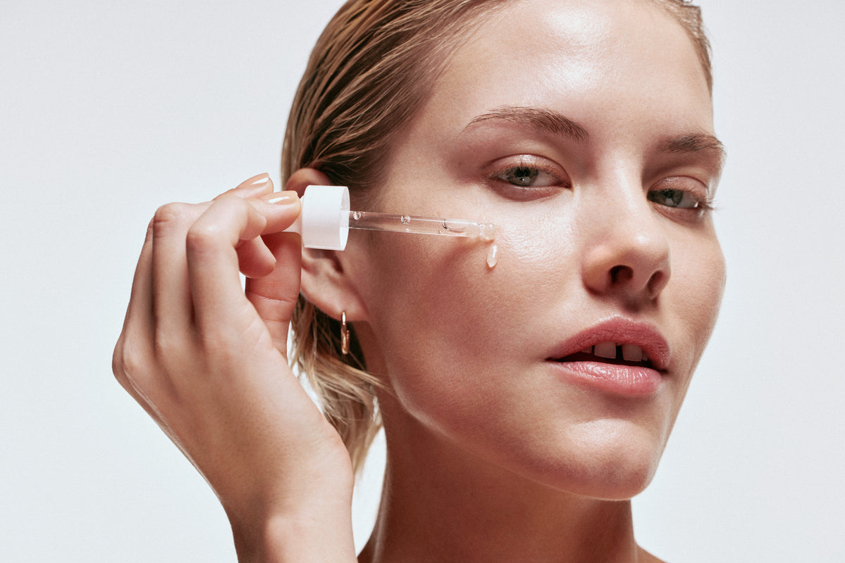 An image of a lady applying serum on her face