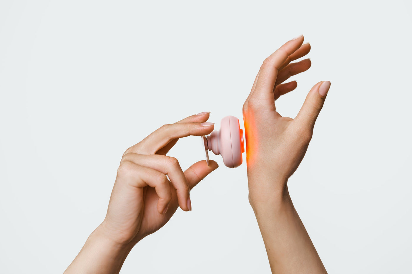 An image of a person using red light therapy on hand for pain