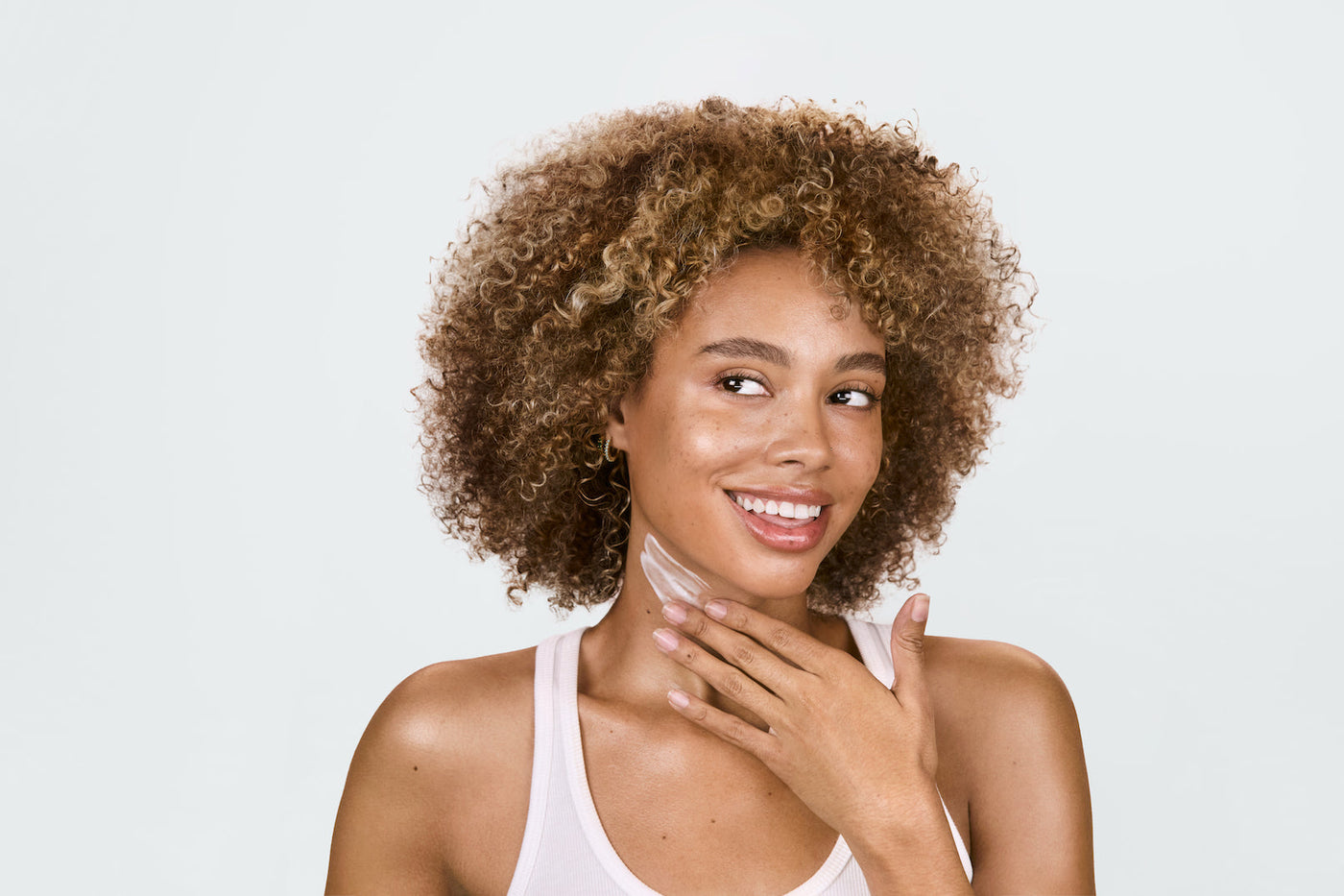 An image of a woman apply Solawave face and nack cream