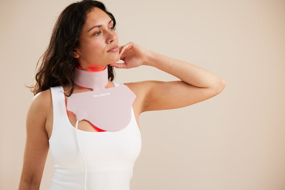 An image of a woman using s neck and chest red light therapy mask for her glow up