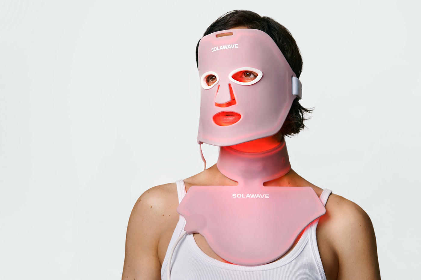 An image of a woman wearing a red light face mask and a red light neck and chest mask for cellulite