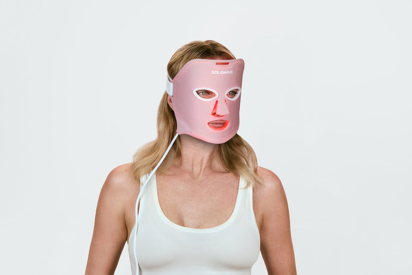 An image of a woman wearing a red light therapy face mask