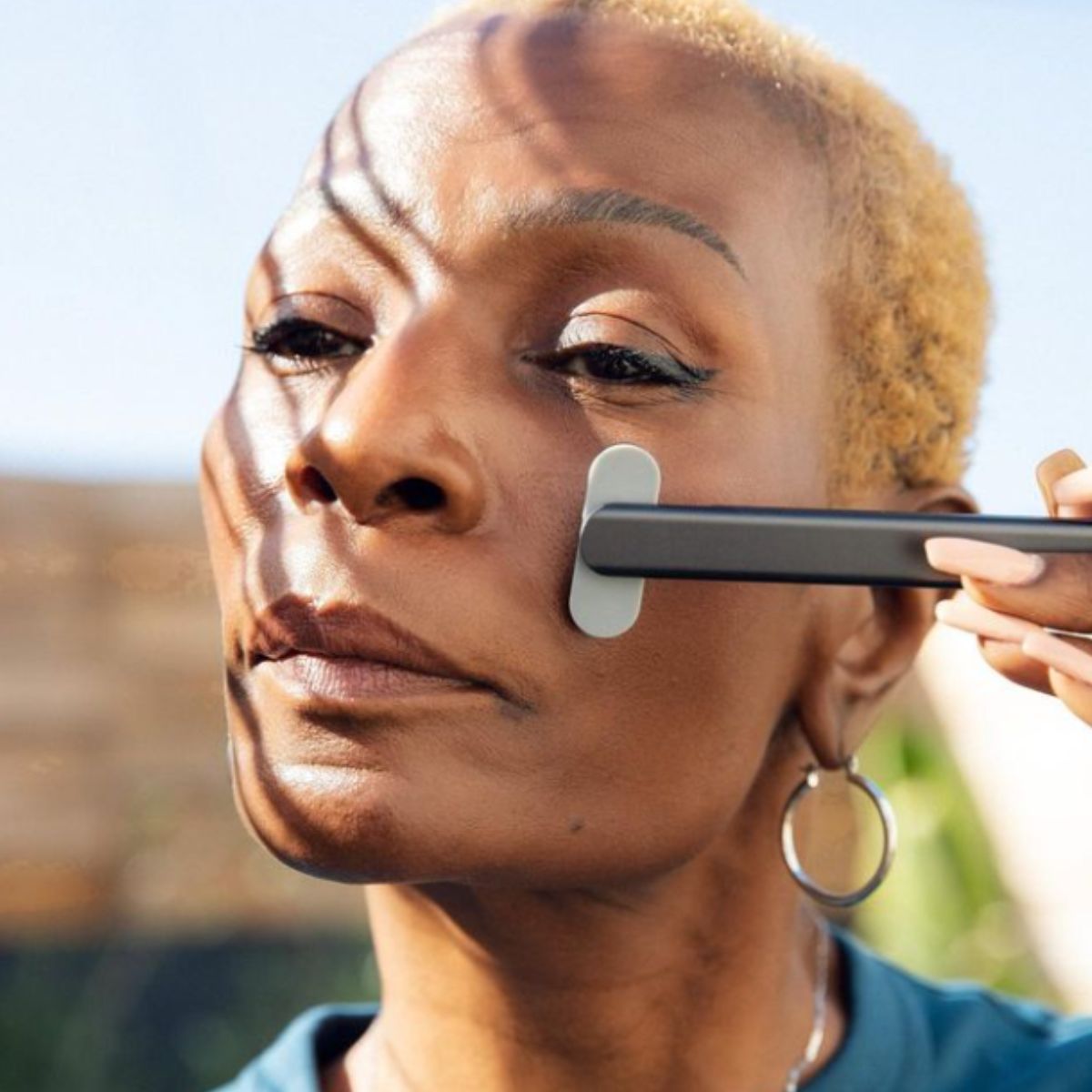 An image of a lady using a red light therapy wand