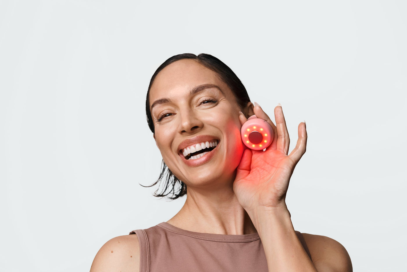 An image of a woman holding up a red light therapy device