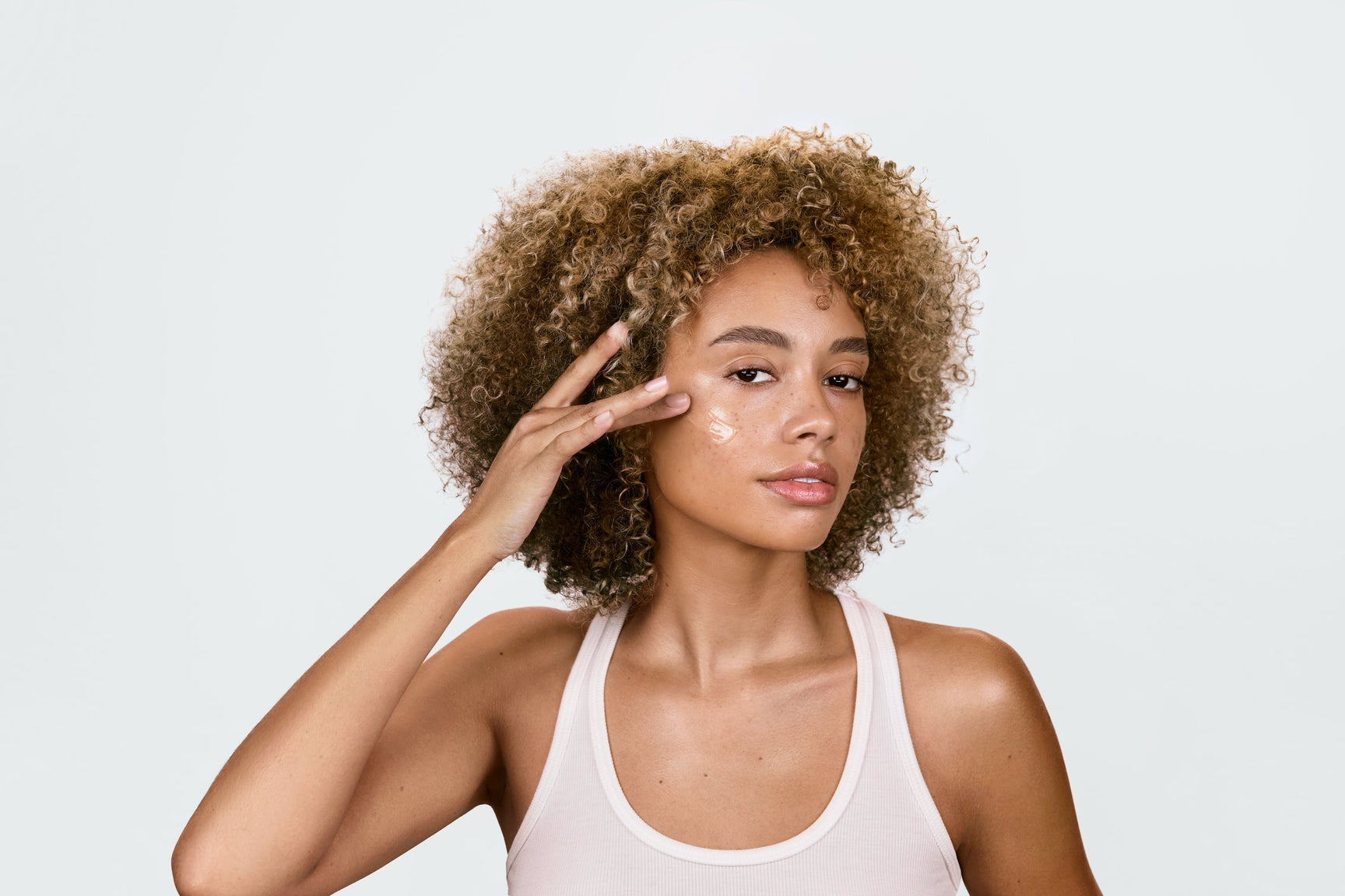 An image of a woman using serum on her face