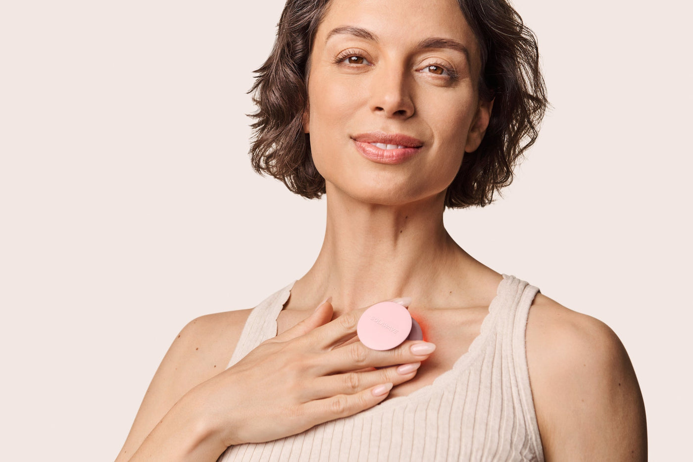 An image of a woman using a red light therapy device on her body