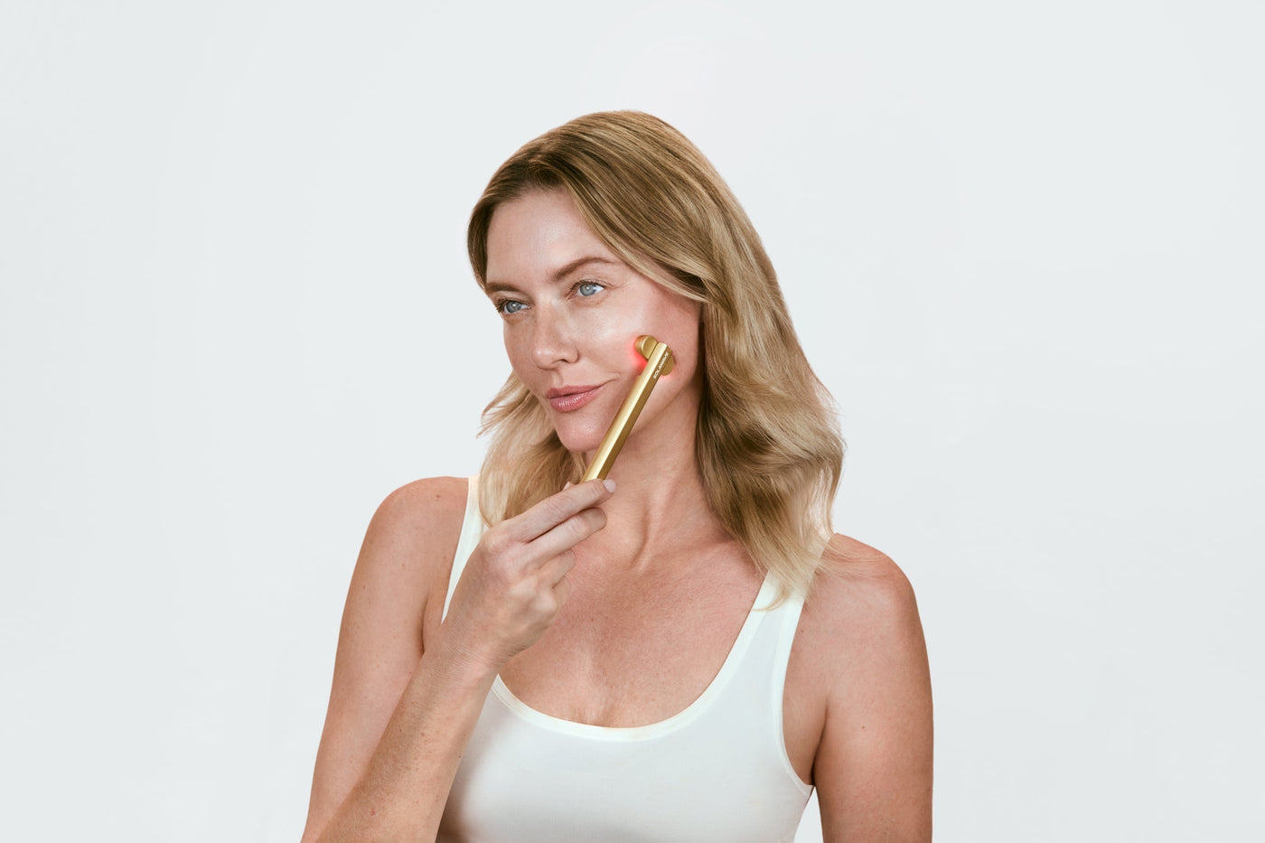 An image of a woman using red light therapy wand