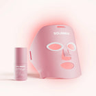 The Wrinkle Retreat Face Mask & LightBoost Serum Kit by Solawave features a rose LED mask, designed with eye, nose, and mouth cutouts for red light therapy. Paired with the pink tube of serum featuring white text, its perfect for targeting fine lines and wrinkles in a softly lit setting.