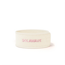 The Get Ready Headband by Solawave is a white fleece accessory with Solawave embroidered in pink on the front. It boasts an adjustable velcro design, perfectly suiting your skincare routine with its clean and minimalist style.