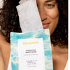 An image of a woman holding hydrating facial masks