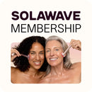 Two women smile while using skincare tools on their cheeks, promoting Inveterates Solawave Membership, which offers the convenience of canceling anytime. The backdrop is a calming light beige.