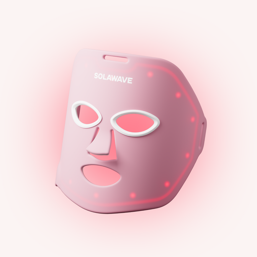 The Solawave Wrinkle Retreat Face Mask Bundle is a pink LED light therapy mask with eye, nose, and mouth cutouts and glowing red lights across its surface.