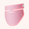 Pink light therapy mask with red LED lights and white brand text, designed for neck and chest treatment.