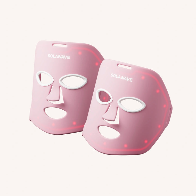 Two Solawave 2x Wrinkle Retreat LED Face Masks with eye, nose, and mouth cutouts glow red on a white background, providing advanced anti-aging and wrinkle reduction treatment.