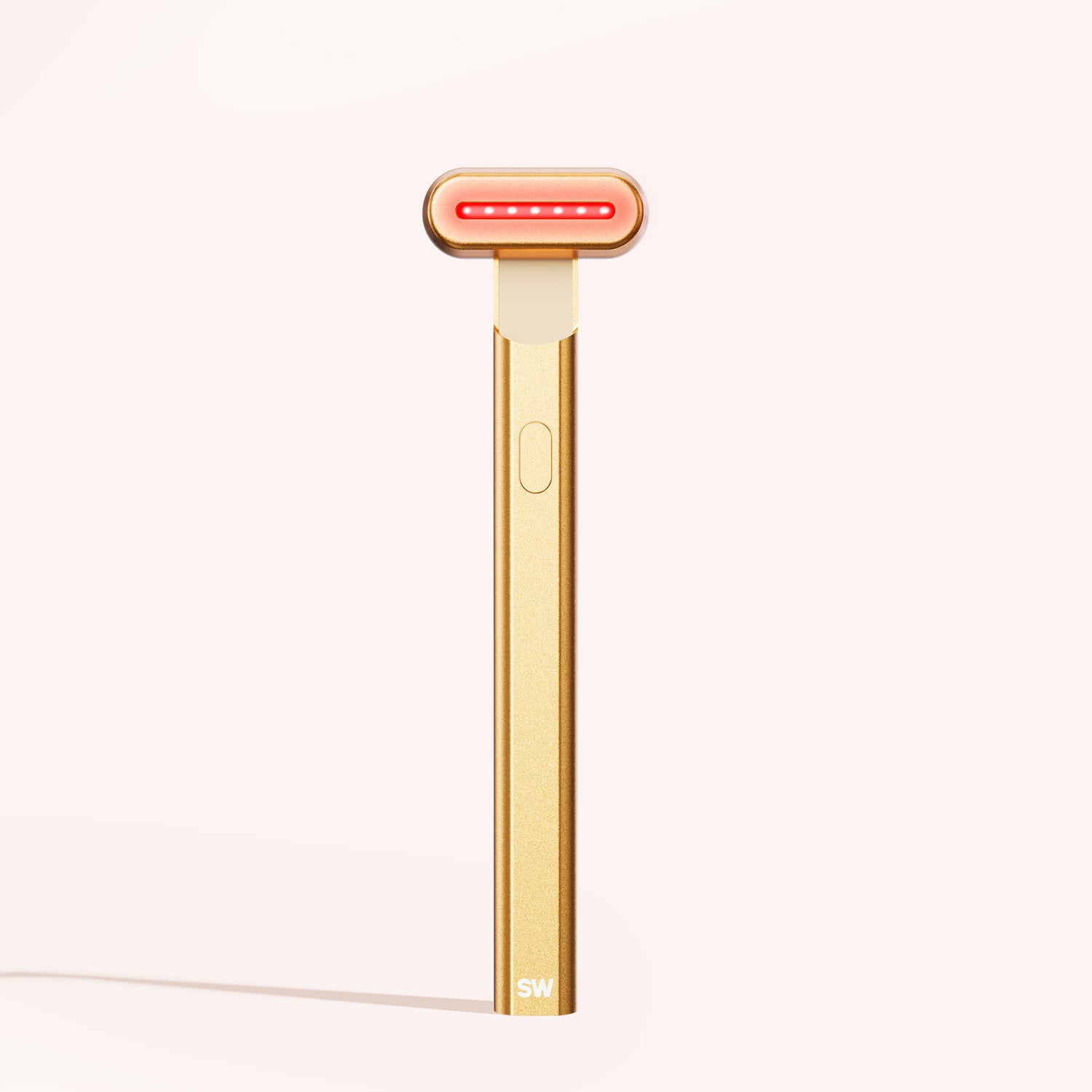 The 4-in-1 Radiant Renewal Skincare Wand by SolaWave, featuring a gold finish and a T-shaped design with red LED lights at the head, stands upright against a light background, highlighting its advanced skincare technology to reduce fine lines. || Gold 