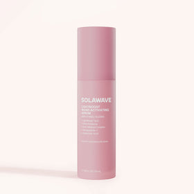 A tall, cylindrical pink bottle of Solawave LightBoost Wand Activating Serum stands against a light background. It features the LightBoost™ Complex, highlights hyaluronic acid and Aloe Vera, and states the volume as 1.5 FL OZ/50 mL.