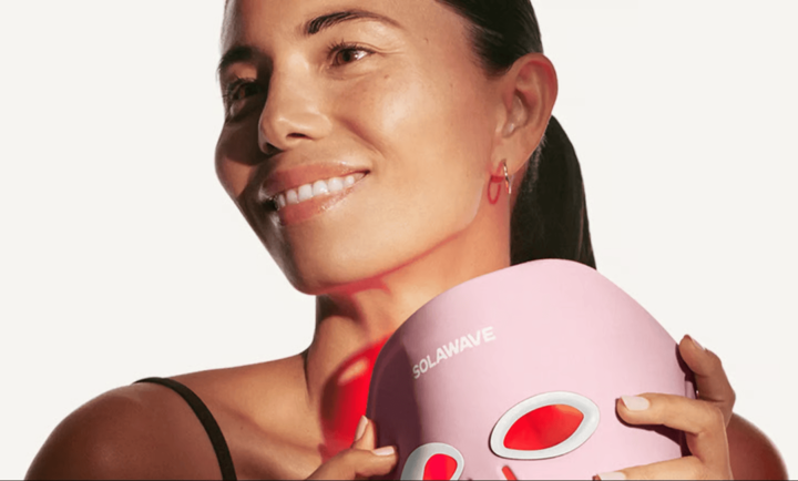Smiling model holding the Wrinkle Retreat Pro mask